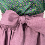Rent this unique handmade green Versatile dirndl with a plum apron from our Munich collection. Perfect for Oktoberfest or elegant events. Available online or in-store.