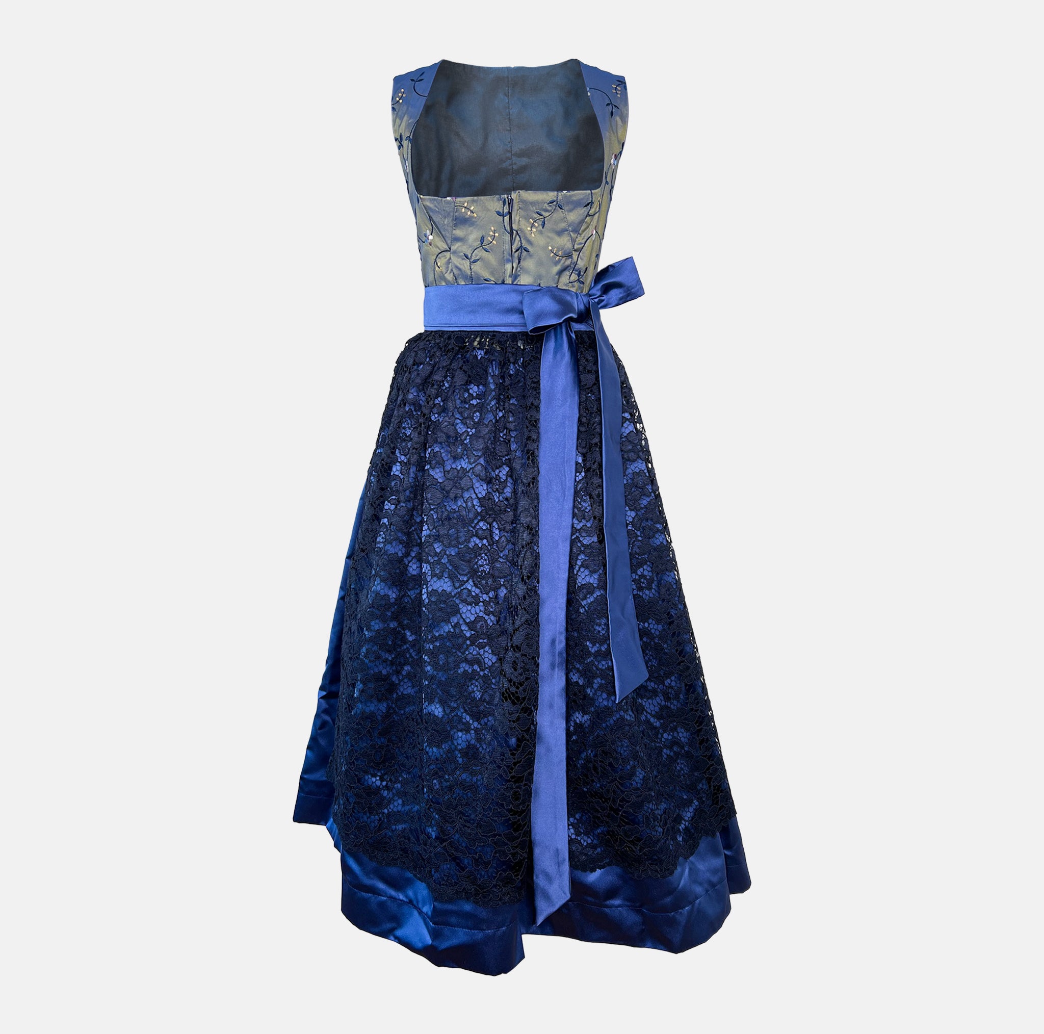 A royal blue traditional dirndl dress with a patterned bodice, lace skirt, and a silky blue ribbon. Rent your Dirndl for Oktoberfest as stunning as this Dirndl
