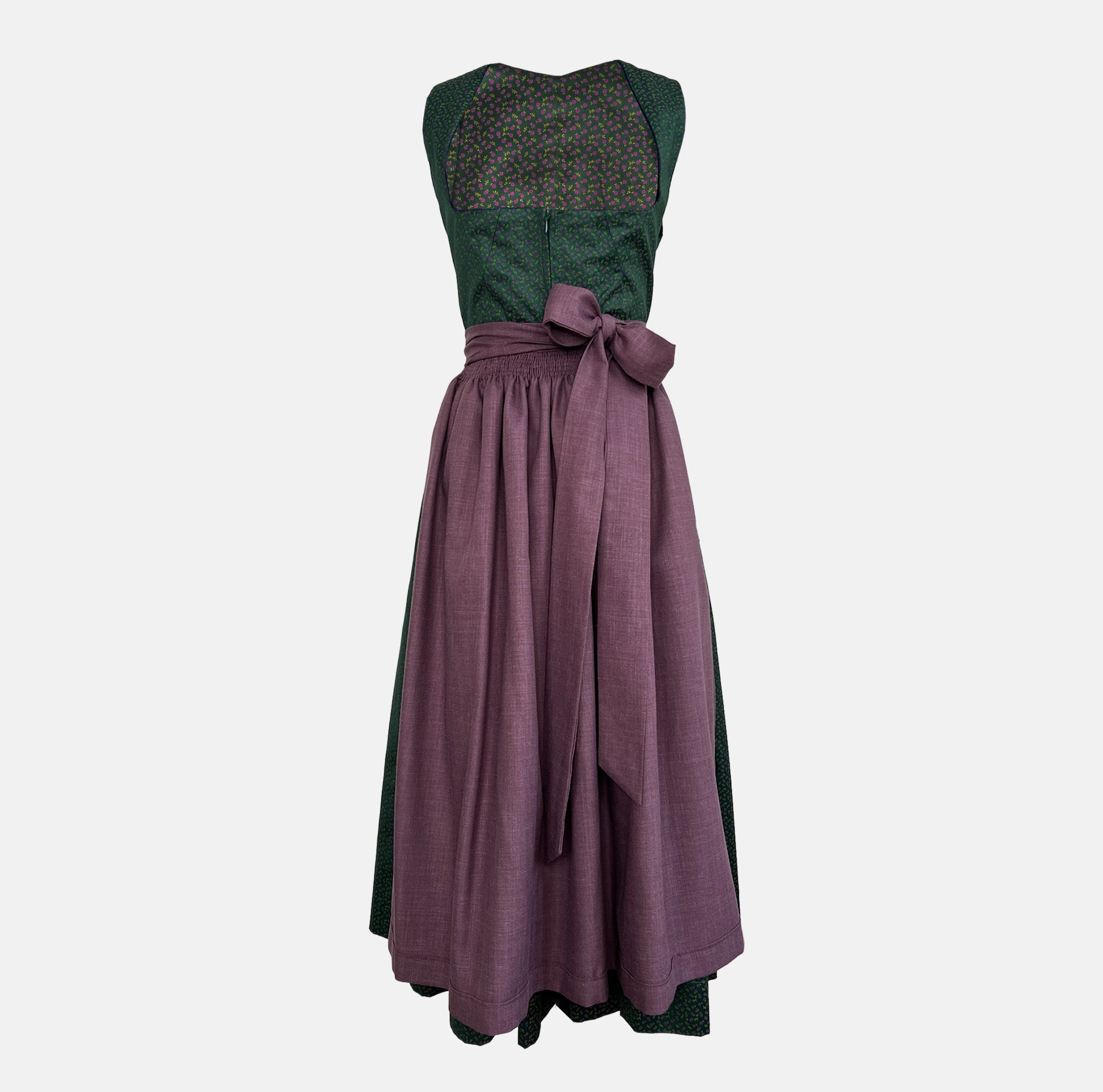 Rent this unique handmade green Versatile dirndl with a plum apron from our Munich collection. Perfect for Oktoberfest or elegant events. Available online or in-store.
