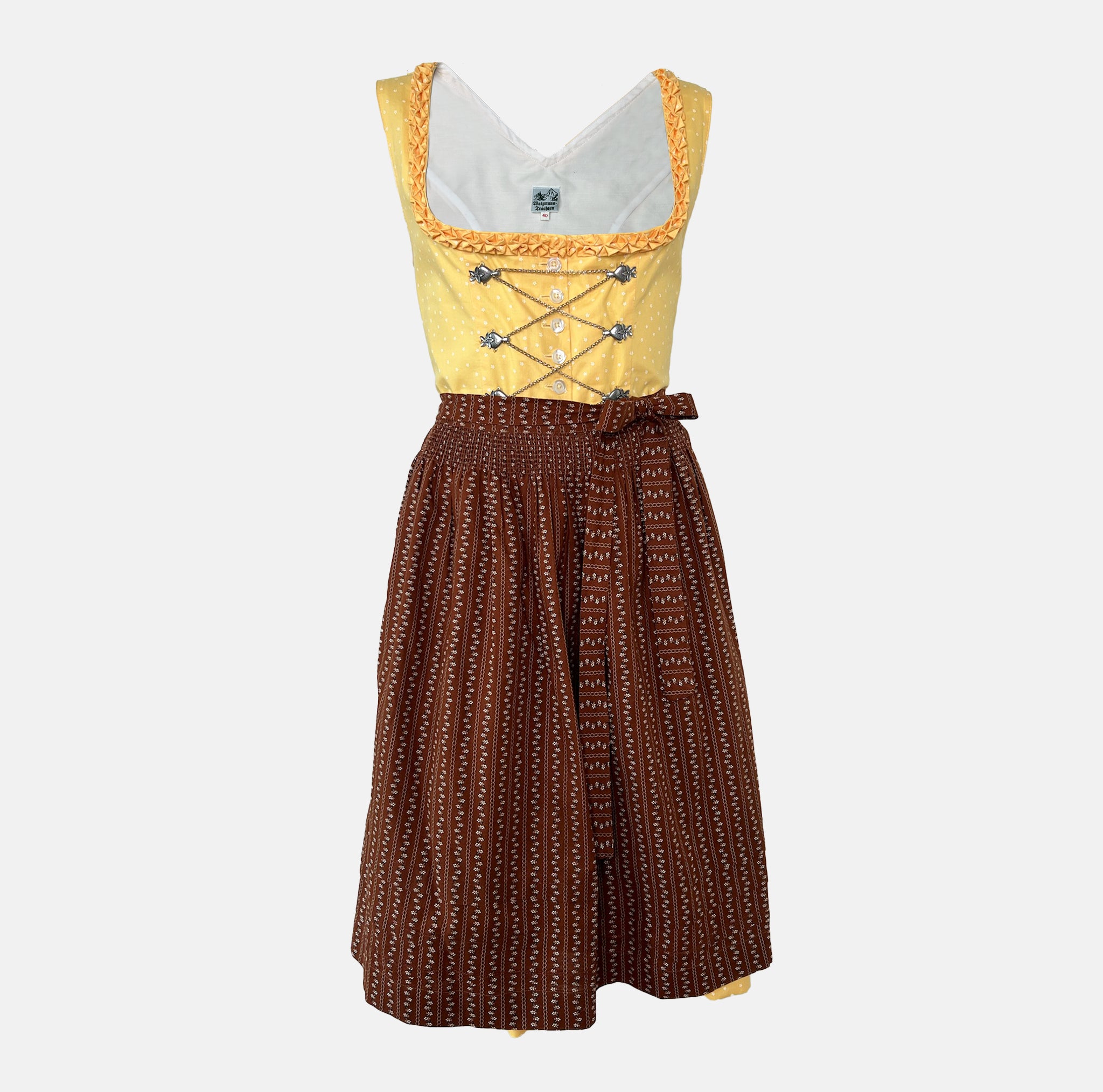 Traditional Watzmann Trachten Dirndl with a yellow bodice, brown patterned skirt, and ribbon detail – available for rent at Versatile OTM.