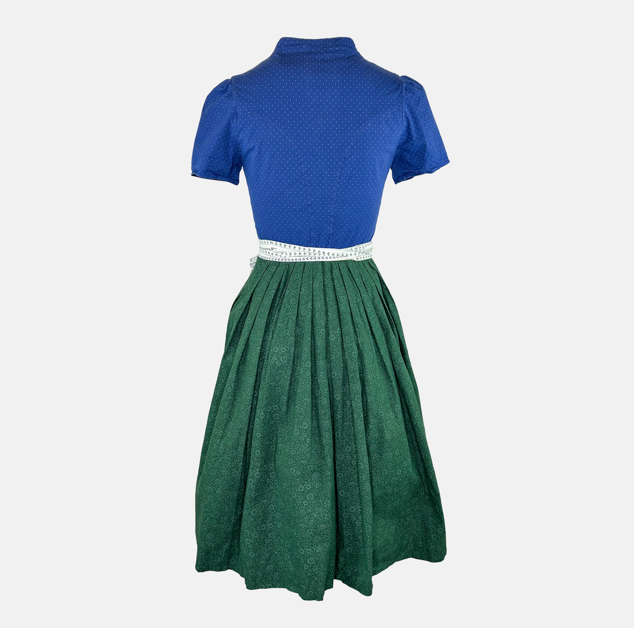 Apple of My Eye dirndl rental via Versatile – deep blue bodice with dotted pattern, white apron with floral stripes, ideal Oktoberfest dress
