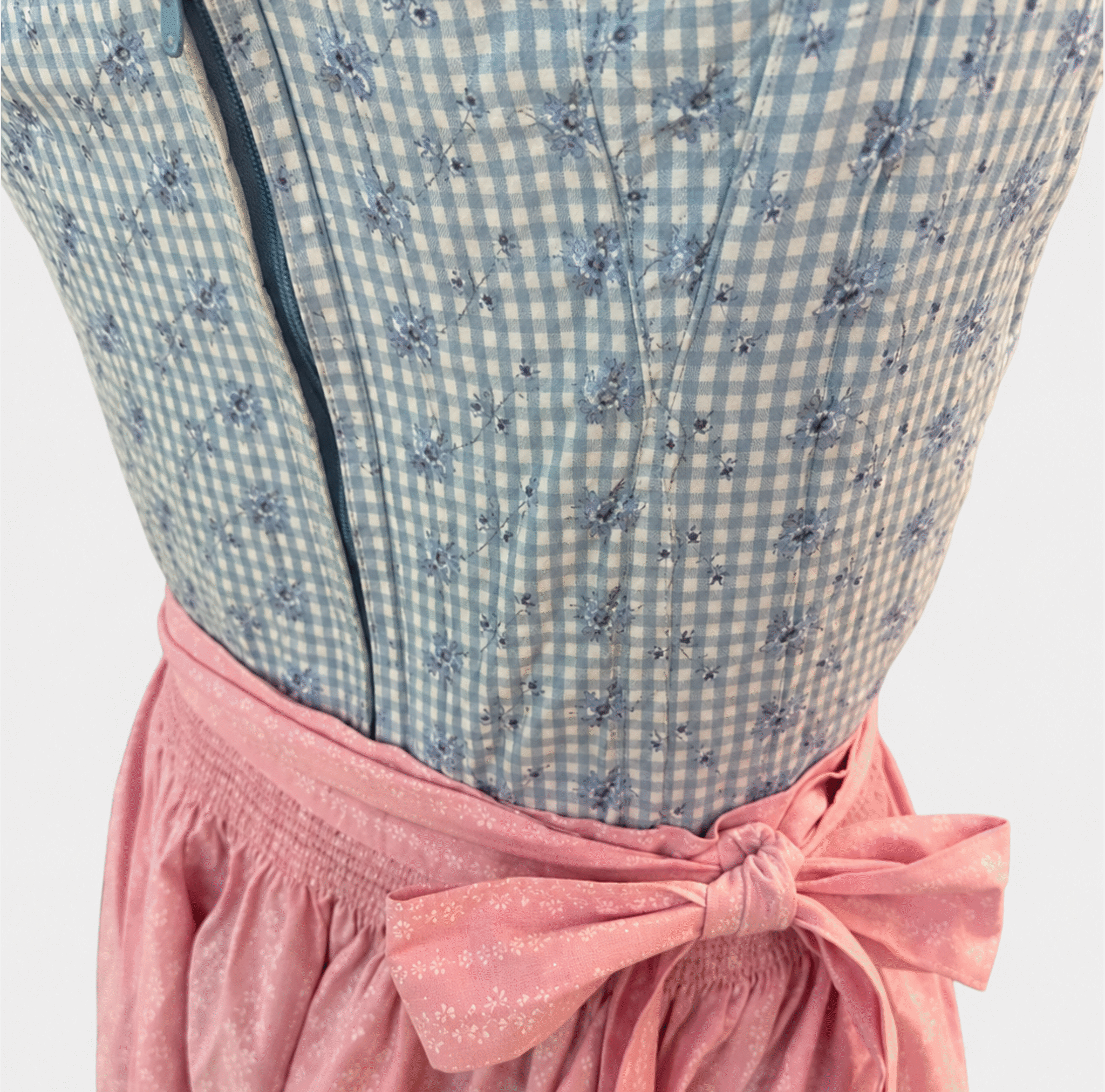 Detail of Berwin & Wolff light blue gingham Dirndl bodice with floral embroidery and pink apron
