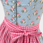 Detail of Berwin & Wolff light blue rose-patterned bodice with fabric-covered buttons and pink gingham apron bow