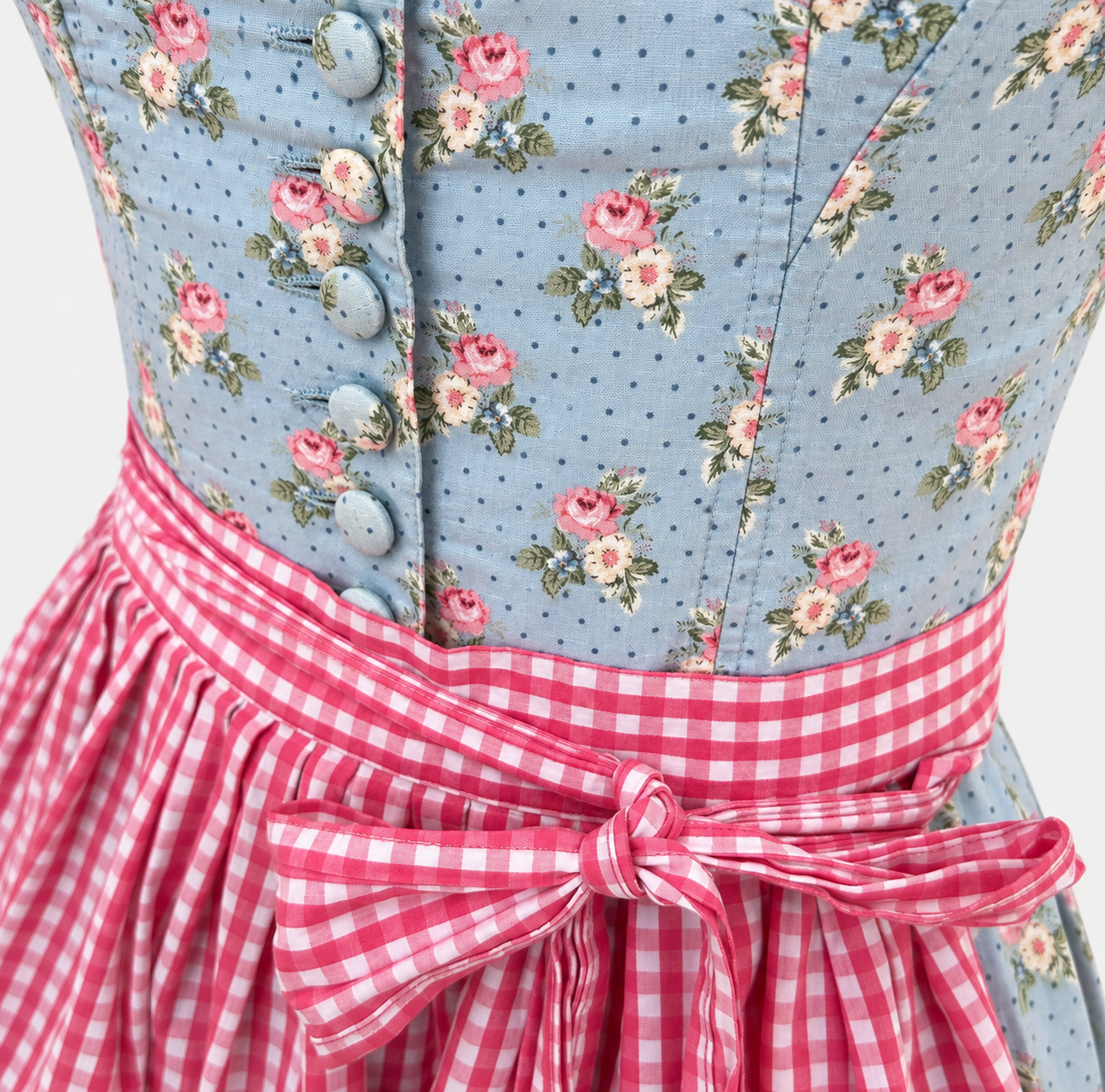 Detail of Berwin & Wolff light blue rose-patterned bodice with fabric-covered buttons and pink gingham apron bow