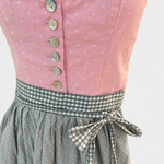 Detail of pink Berwin & Wolff Dirndl bodice with pale buttons, small white motifs and grey gingham apron bow
