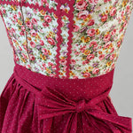 Close-up of Berwin & Wolff Dirndl with floral bodice, red trim and dotted apron bow