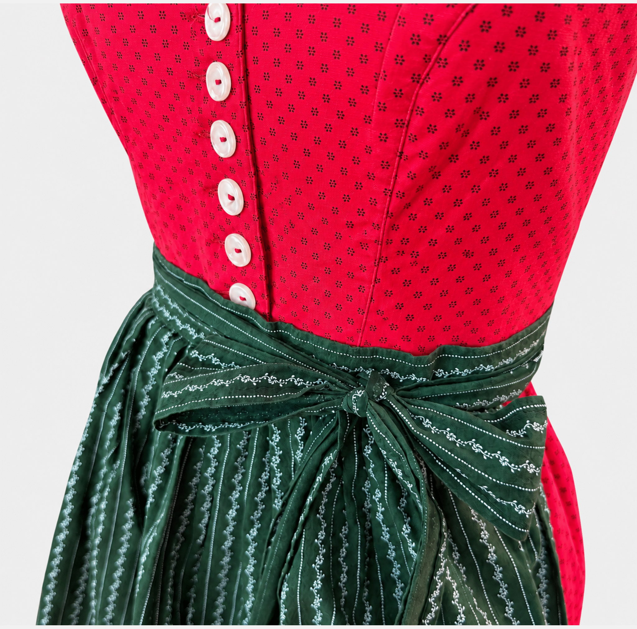 Detail of Berwin & Wolff red Dirndl bodice with white buttons and dark green patterned apron