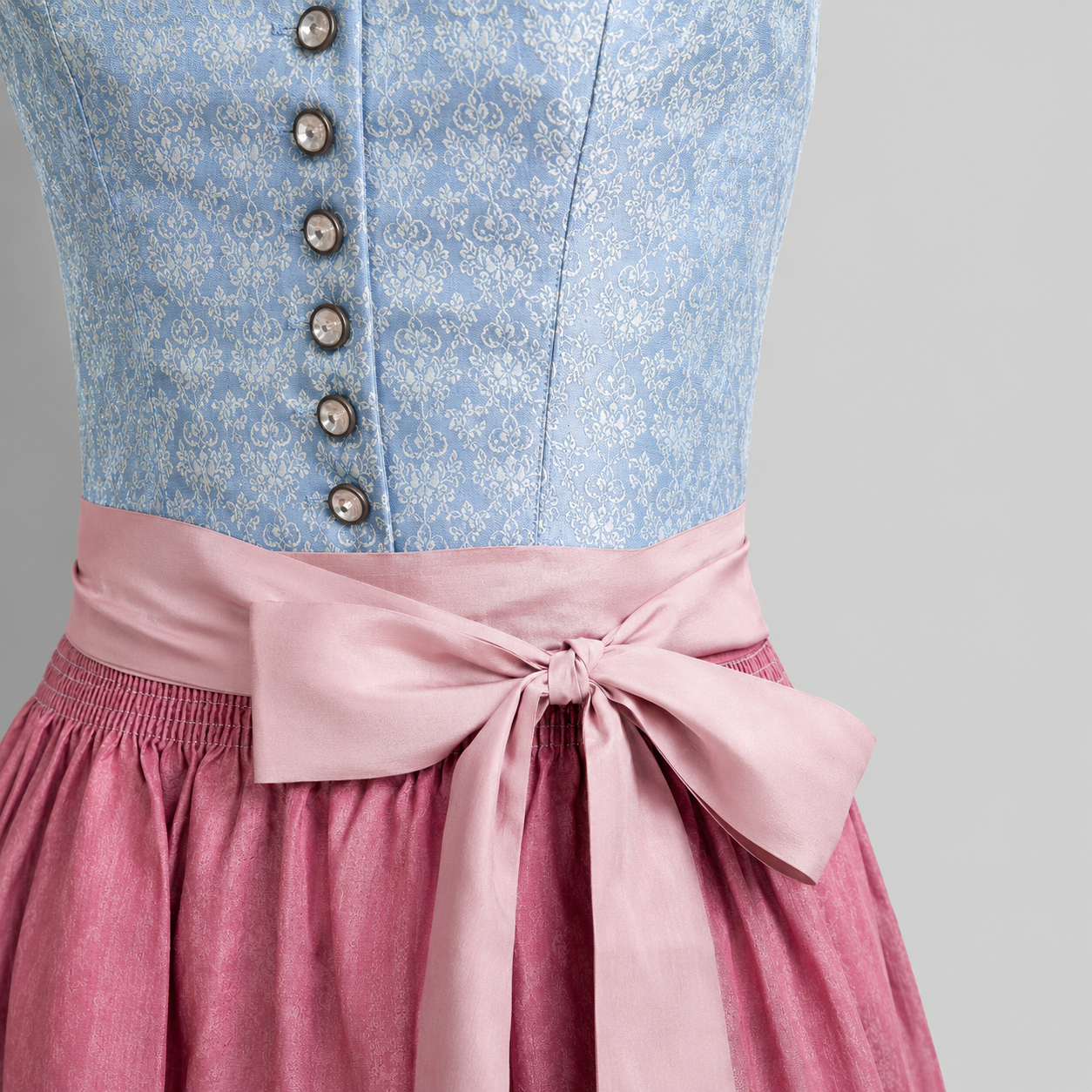 Detail of light blue Heimatgwand Dirndl bodice with white floral pattern, decorative buttons and pink trim