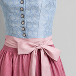 Detail of light blue Heimatgwand Dirndl bodice with white floral pattern, decorative buttons and pink trim