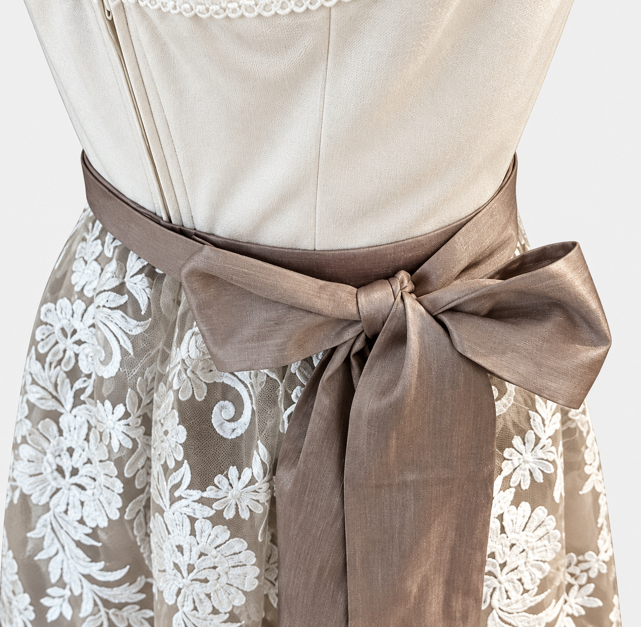 Detail of Krüger gold Dirndl with cream bodice, taupe waist bow and ivory floral lace apron