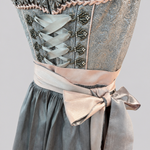 Detail of grey Krüger Dirndl bodice with ornamental hooks, ribbon lacing and soft pink apron bow