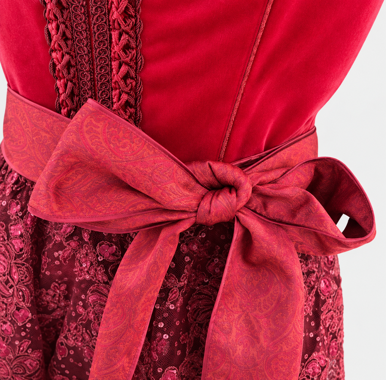Detail of Krüger red Dirndl with braided bodice trim, paisley apron bow and floral lace