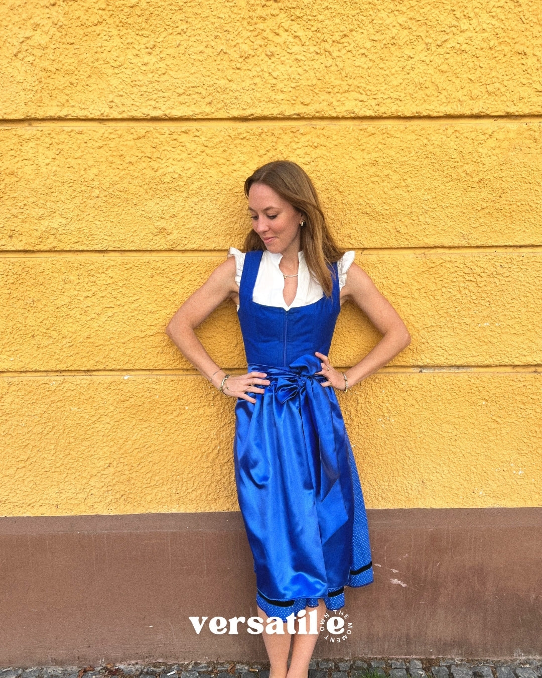 Munich Oktoberfest rental: Ma.Le.Ma crafted royal-blue dirndl with square neckline, silk skirt, satin bow apron, and playful dotted underskirt detail.
