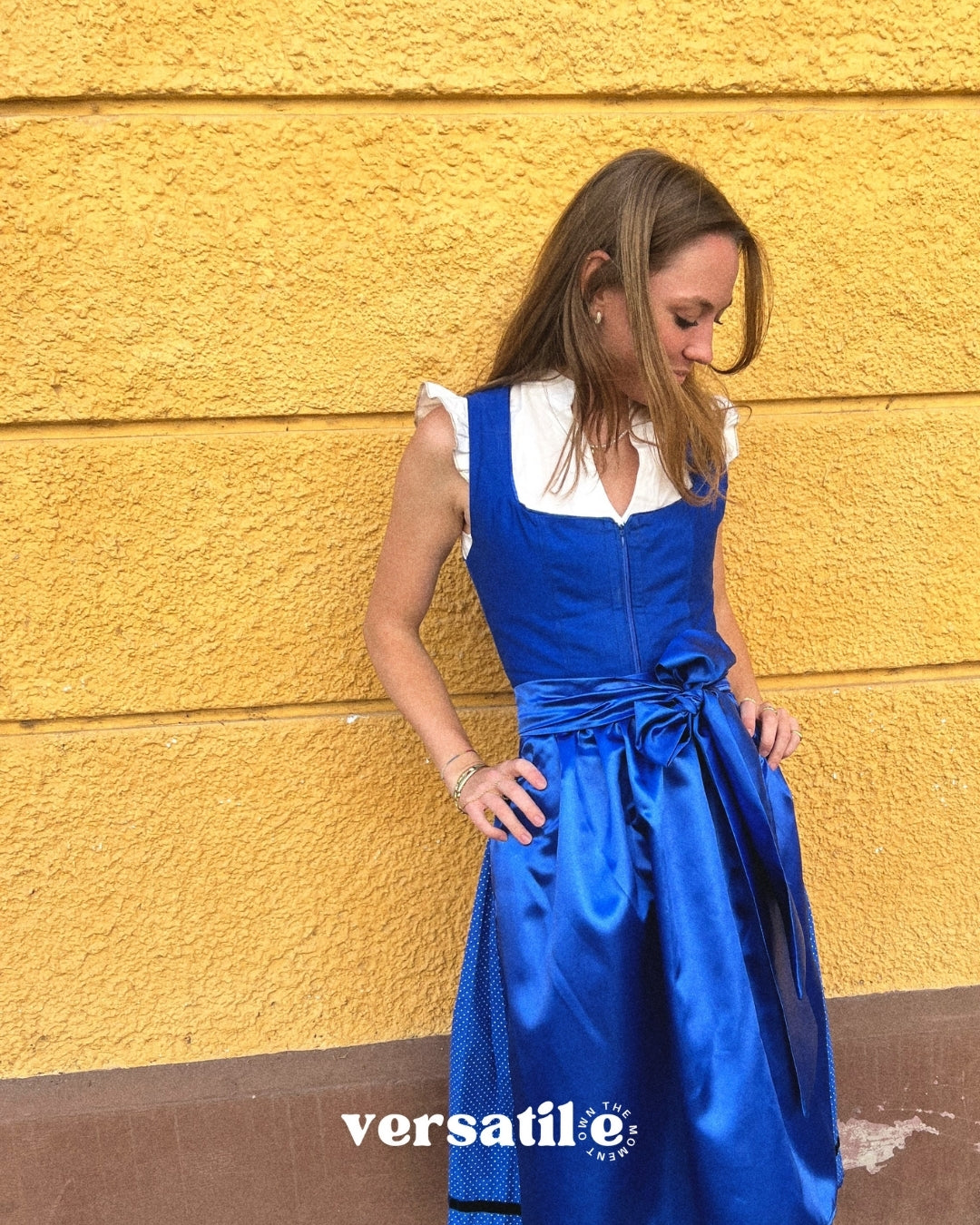 Handmade Ma.Le.Ma dirndl in royal blue—structured bodice, classic square neckline, silk skirt with wide bow apron and dotted underskirt; available for Oktoberfest rental in Munich.