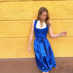 Alpine chic Ma.Le.Ma dirndl rental: deep royal blue with square-neck bodice, silk skirt, statement bow apron, and dotted underskirt—perfect for celebrating Oktoberfest in Munich.