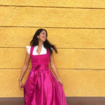 Handcrafted Ma.Le.Ma fuchsia dirndl, square neck and bow apron, available for rental in Munich for Oktoberfest celebrations.