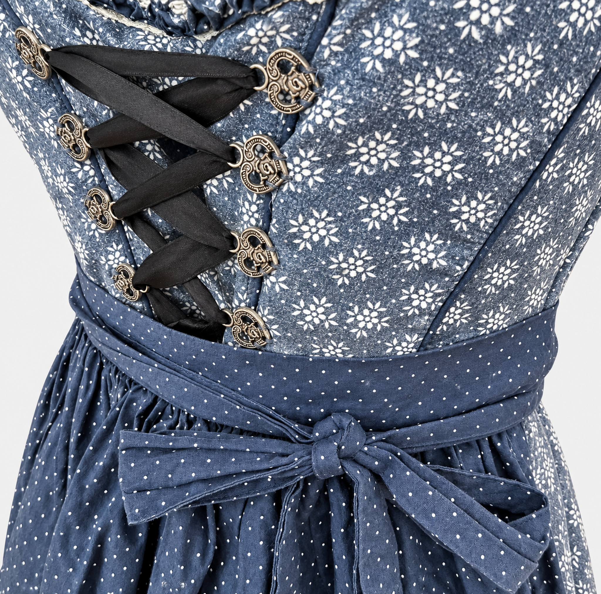 Detail of Marjo blue floral bodice with decorative metal hooks, dark ribbon lacing and navy dotted apron bow
