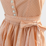 Detail of Turi Landhaus apricot Dirndl with white buttons, dotted bodice and floral apron bow